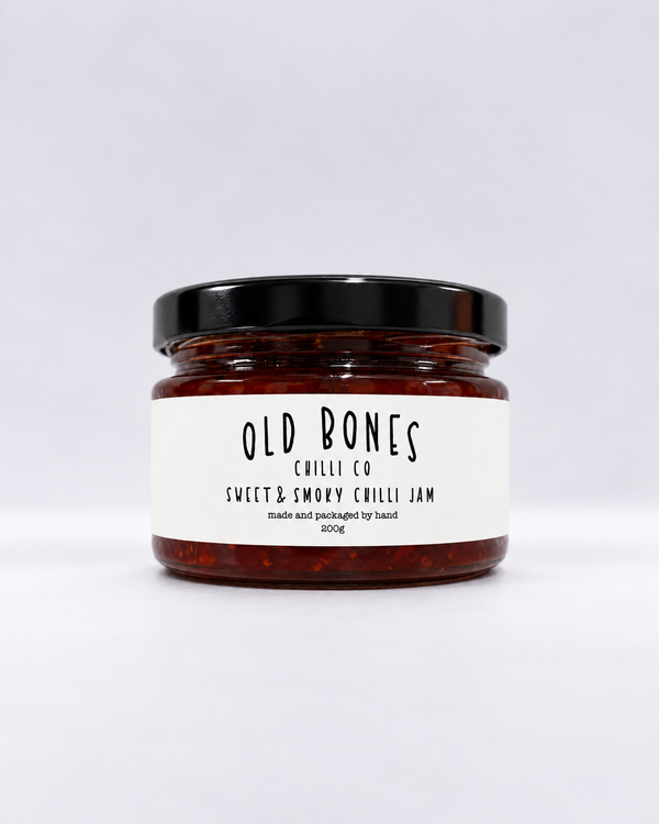 A glass jar of Old Bones Chilli Co Sweet & Smoky Chilli Jam 200g with a black lid and a white label, set against a clean white background.